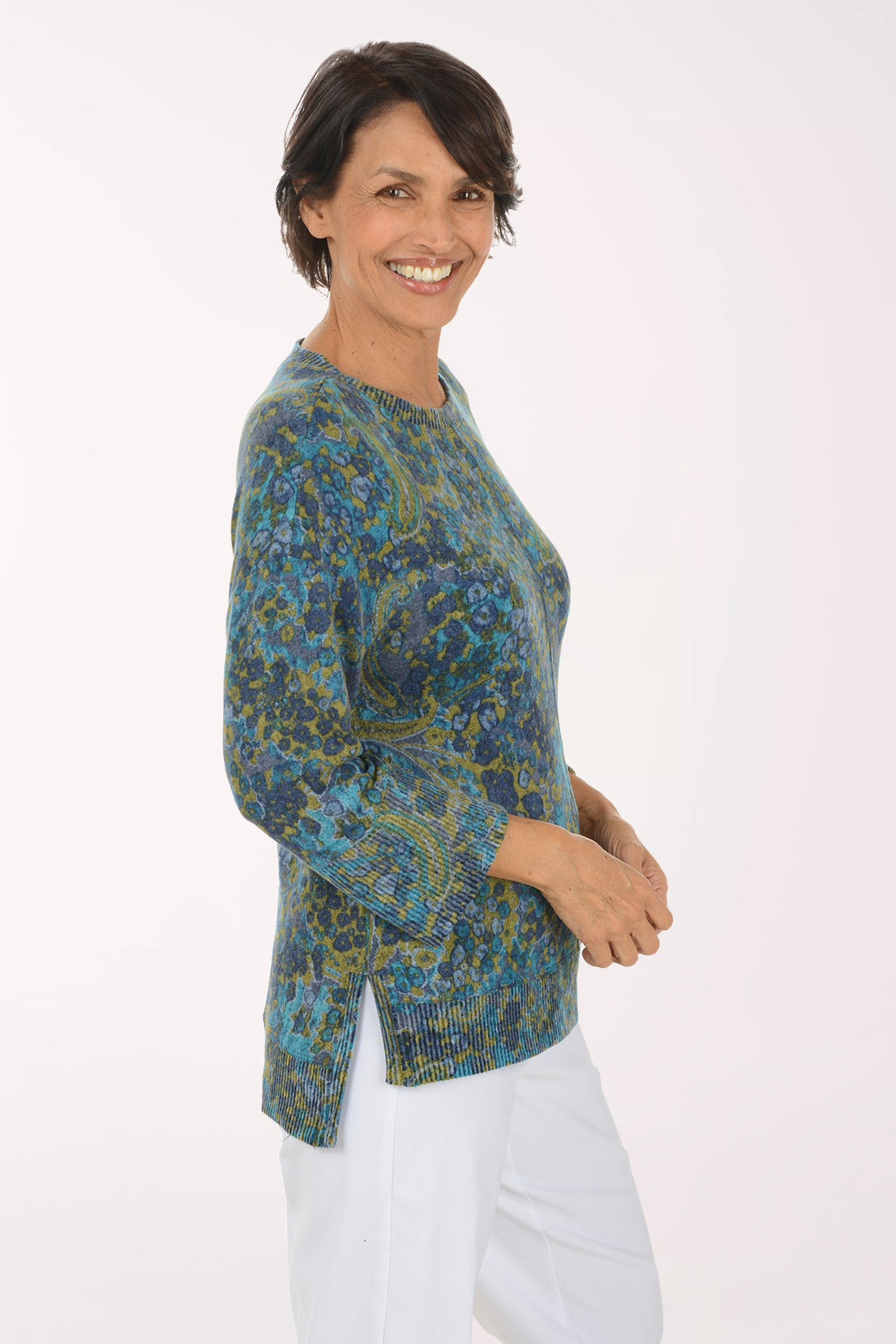 Woman wearing a blue multi colored paisley knit top with 3/4 sleeves