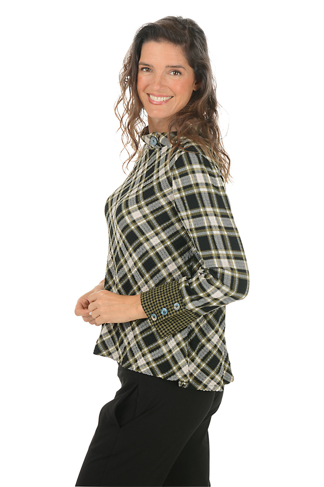 Woman wearing a green and black contrasting plaid shirt on a white background. Side shot.