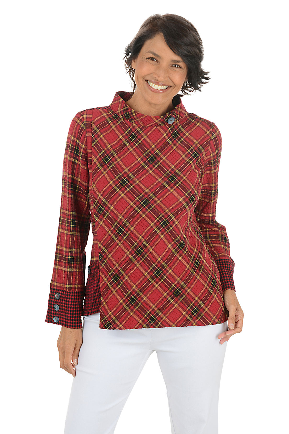 Woman wearing a contrasting plaid red and yellow shirt and white pants on a white background.