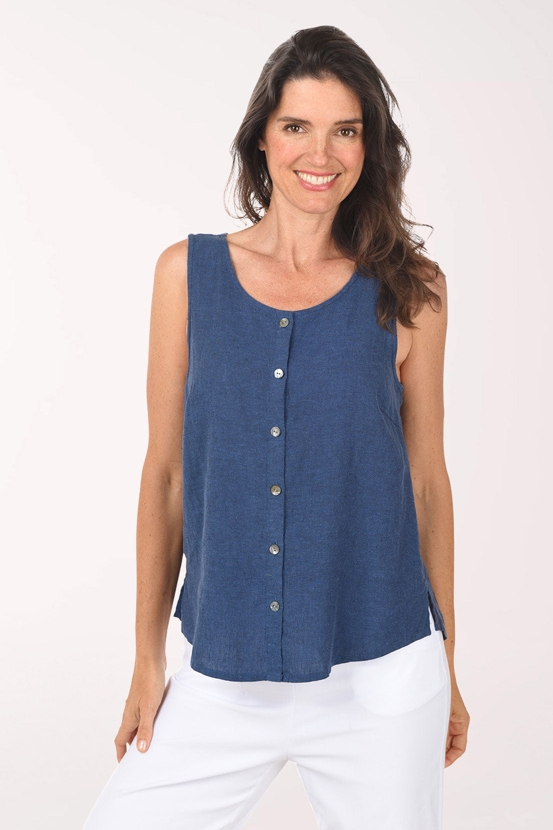 Woman wearing a blue sleeveless top with buttons on a white background