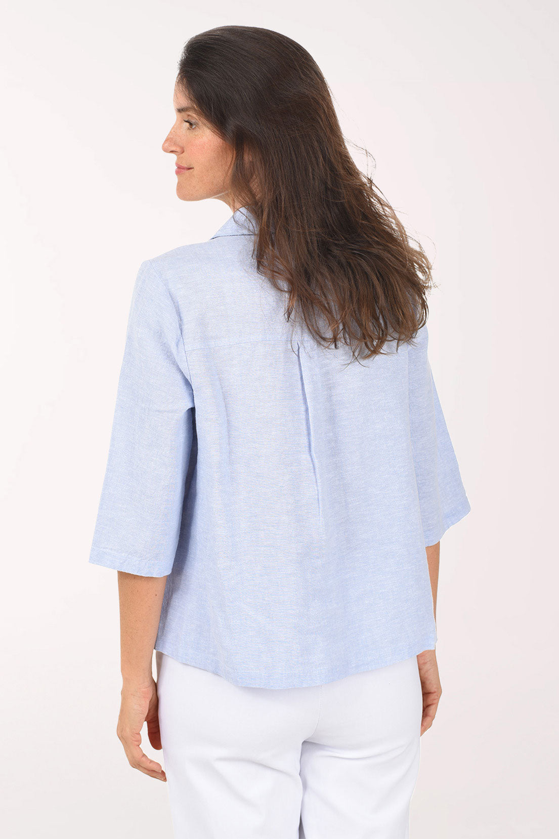 Woman wearing a light blue shirt against a white background