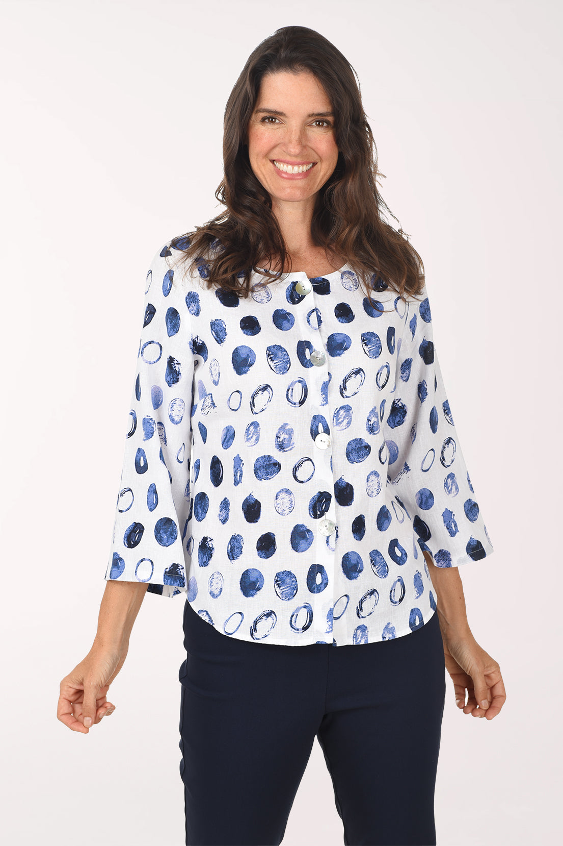 Woman wearing a white blouse with blue abstract pattern on a white background