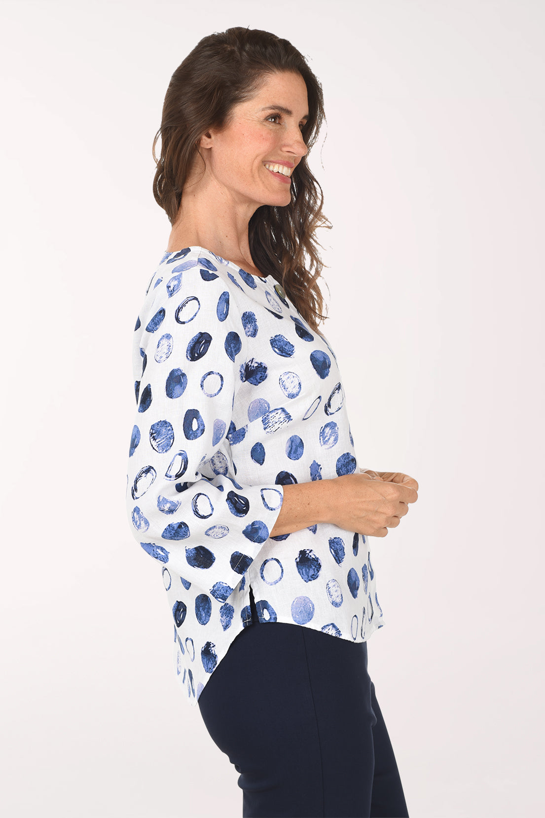 Woman wearing a white blouse with blue abstract pattern on a white background