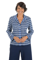 Woman wearing a blue patterned blouse on a white background.