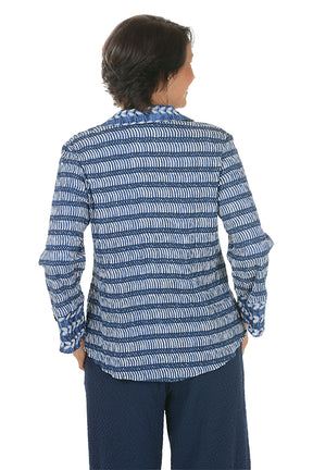 Woman wearing a blue patterned blouse on a white background. Back shot.