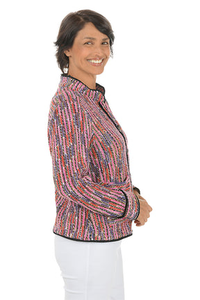 Woman wearing a colorful textured jacket on a white background. Side shot.