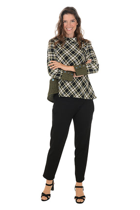 Woman wearing a plaid jacket and black pants on a white background.