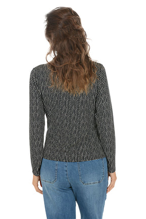 Woman wearing a black and white patterned long-sleeve top and blue jeans on a white background. Back shot.