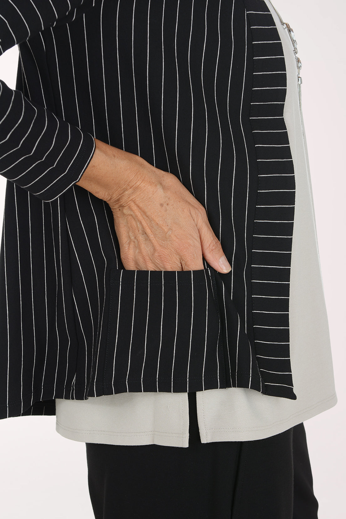 Woman wearing a black and white striped open front jacket 