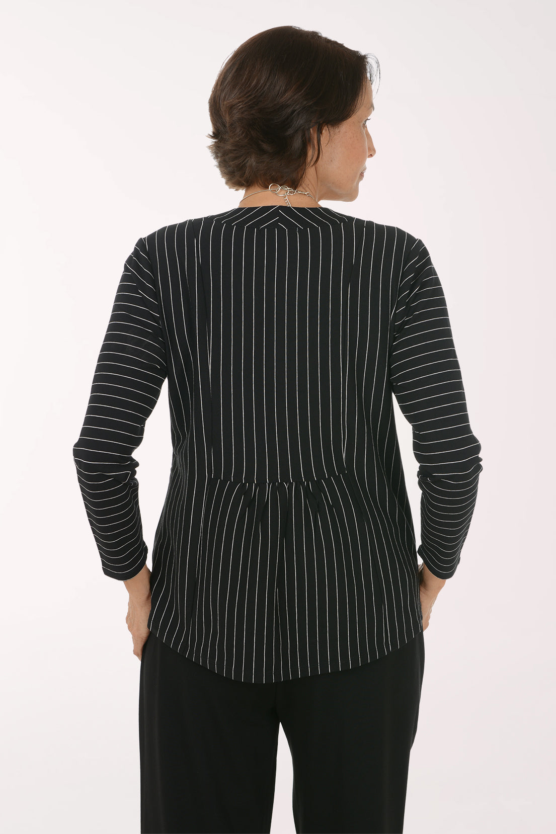 Woman wearing a black and white striped open front jacket 