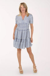 Woman wearing a blue and white patterned dress on a white background