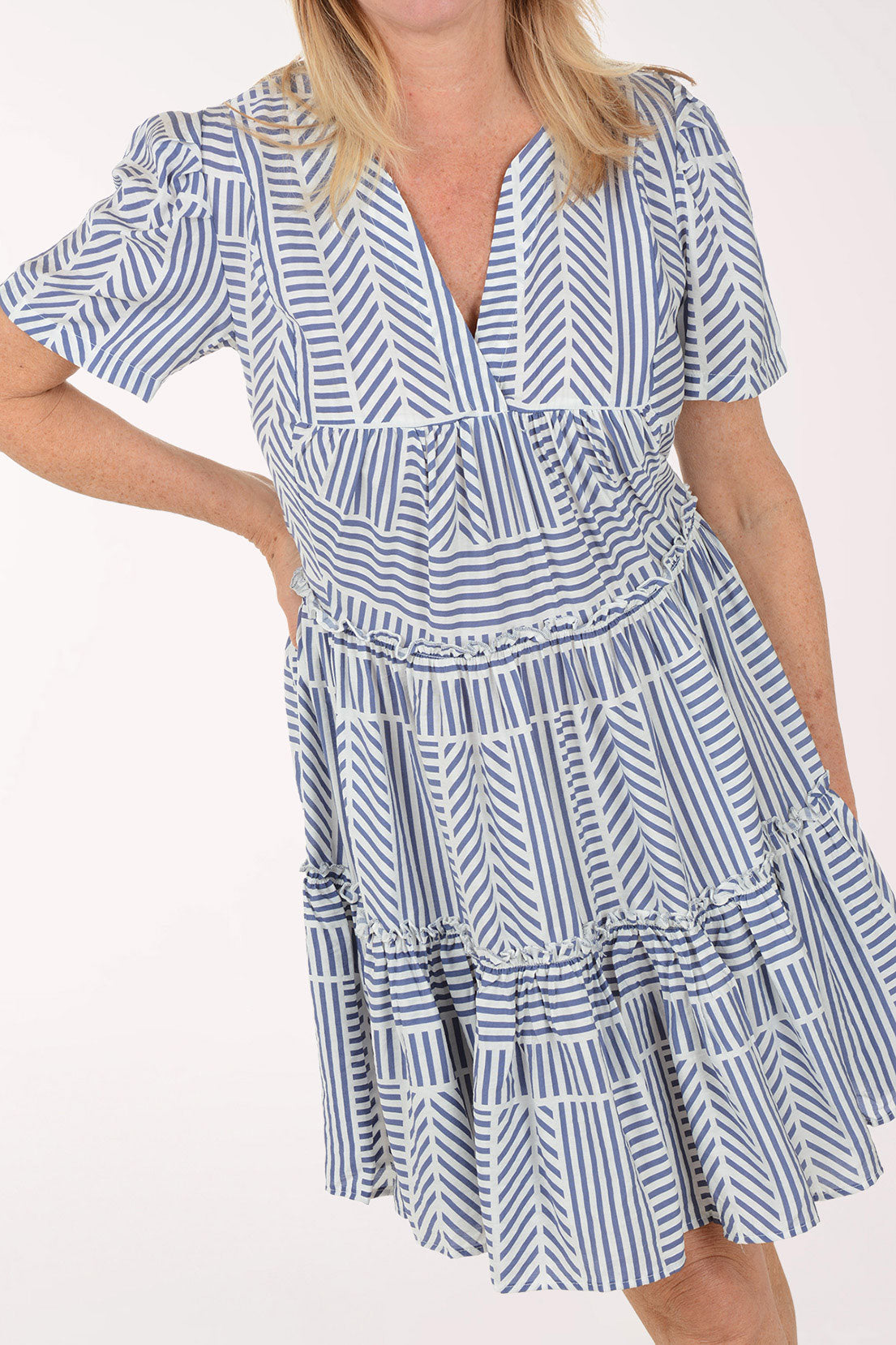 Woman wearing a blue and white patterned dress on a white background