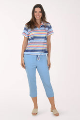 Woman wearing a striped polo shirt and light blue pants on a white background