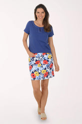 Woman wearing a blue top and floral skirt on a white background