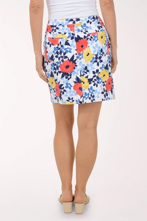 Person wearing a colorful floral skirt on a white background