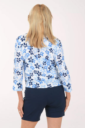 Woman wearing a blue floral blouse and navy shorts on a white background