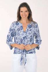 Woman wearing a blue floral blouse with a white background