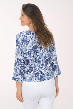 Woman wearing a blue floral blouse with a white background