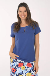 Woman wearing a blue top and floral skirt on a white background