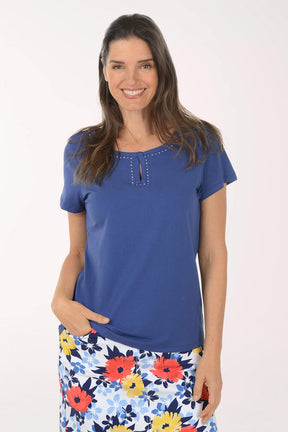 Woman wearing a blue top and floral skirt on a white background
