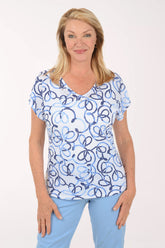 Woman wearing a blue and white patterned top with light blue pants on a white background