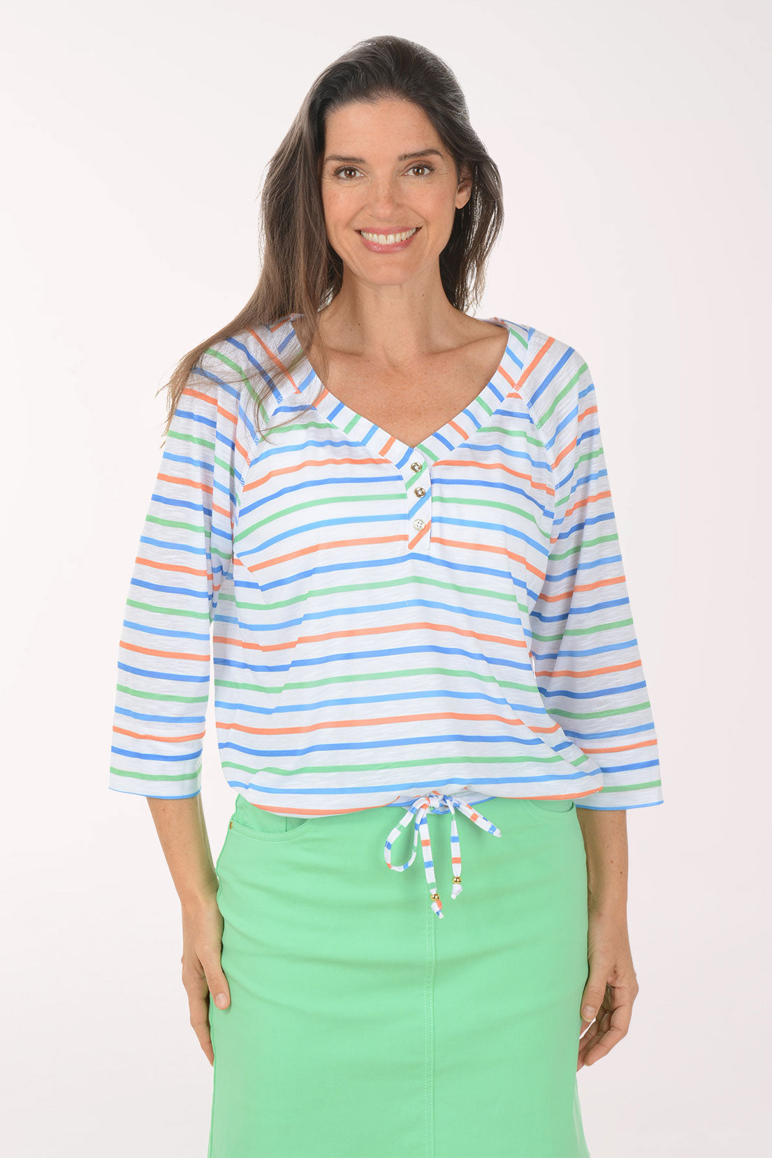 Woman wearing a colorful striped top and green skirt on a white background