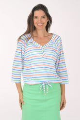 Woman wearing a colorful striped top and green skirt on a white background