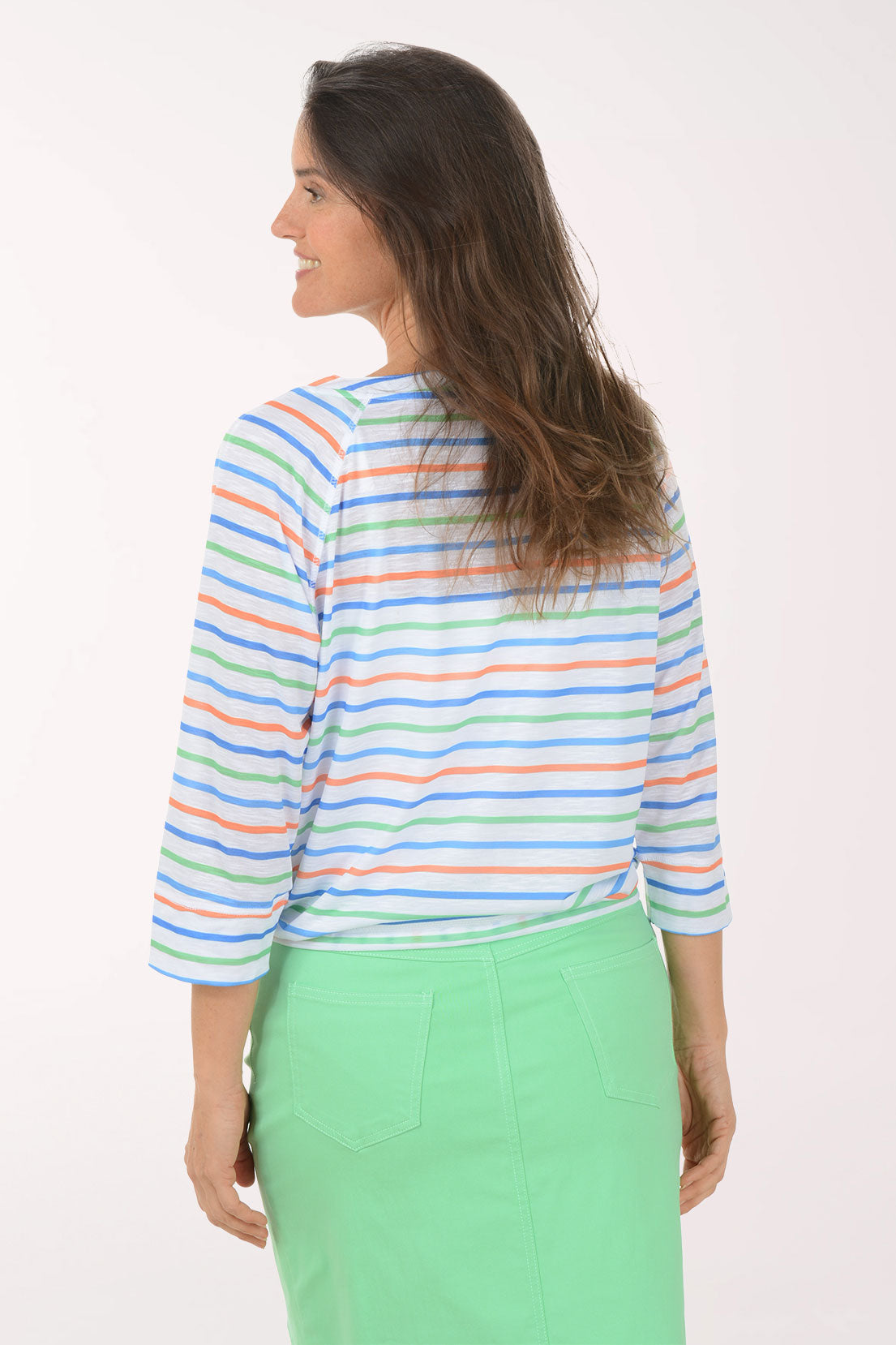 Woman wearing a colorful striped top and green skirt on a white background