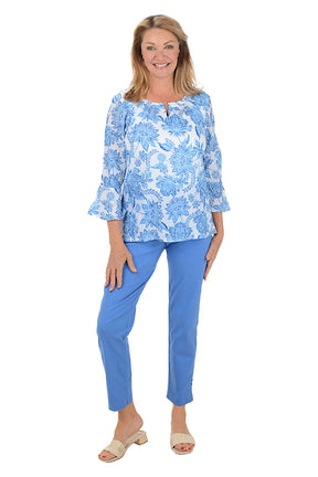 Woman wearing a blue floral top and matching pants on a white background.