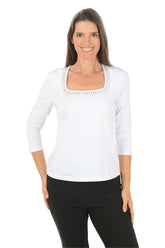 Woman wearing a white long-sleeve top with black pants on a white background.