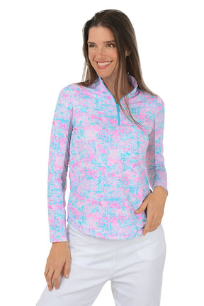 Woman wearing a colorful long-sleeve shirt with a white background.