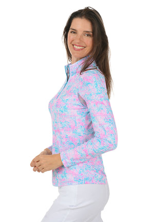 Woman wearing a colorful long-sleeve shirt with a white background. Side shot.