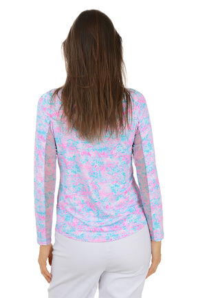 Woman wearing a colorful long-sleeve shirt with a white background. Back shot.