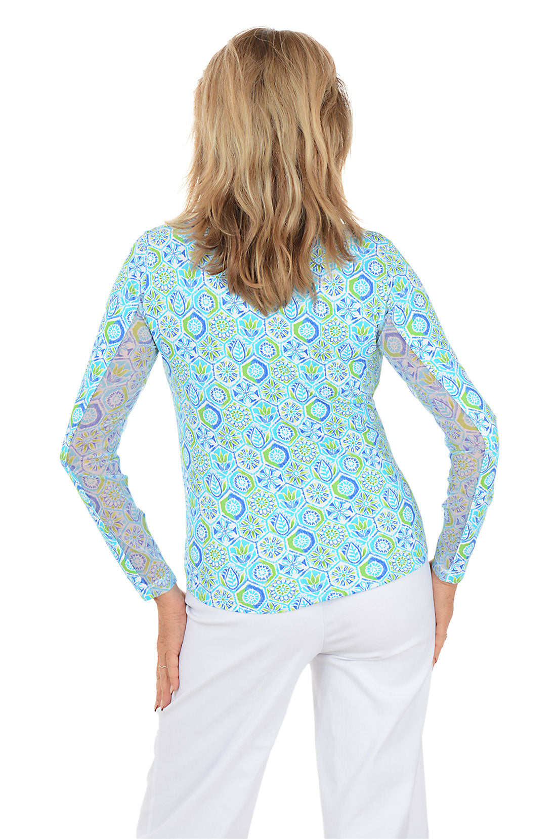 Woman wearing a patterned long-sleeve shirt and white pants on a white background. Back shot.