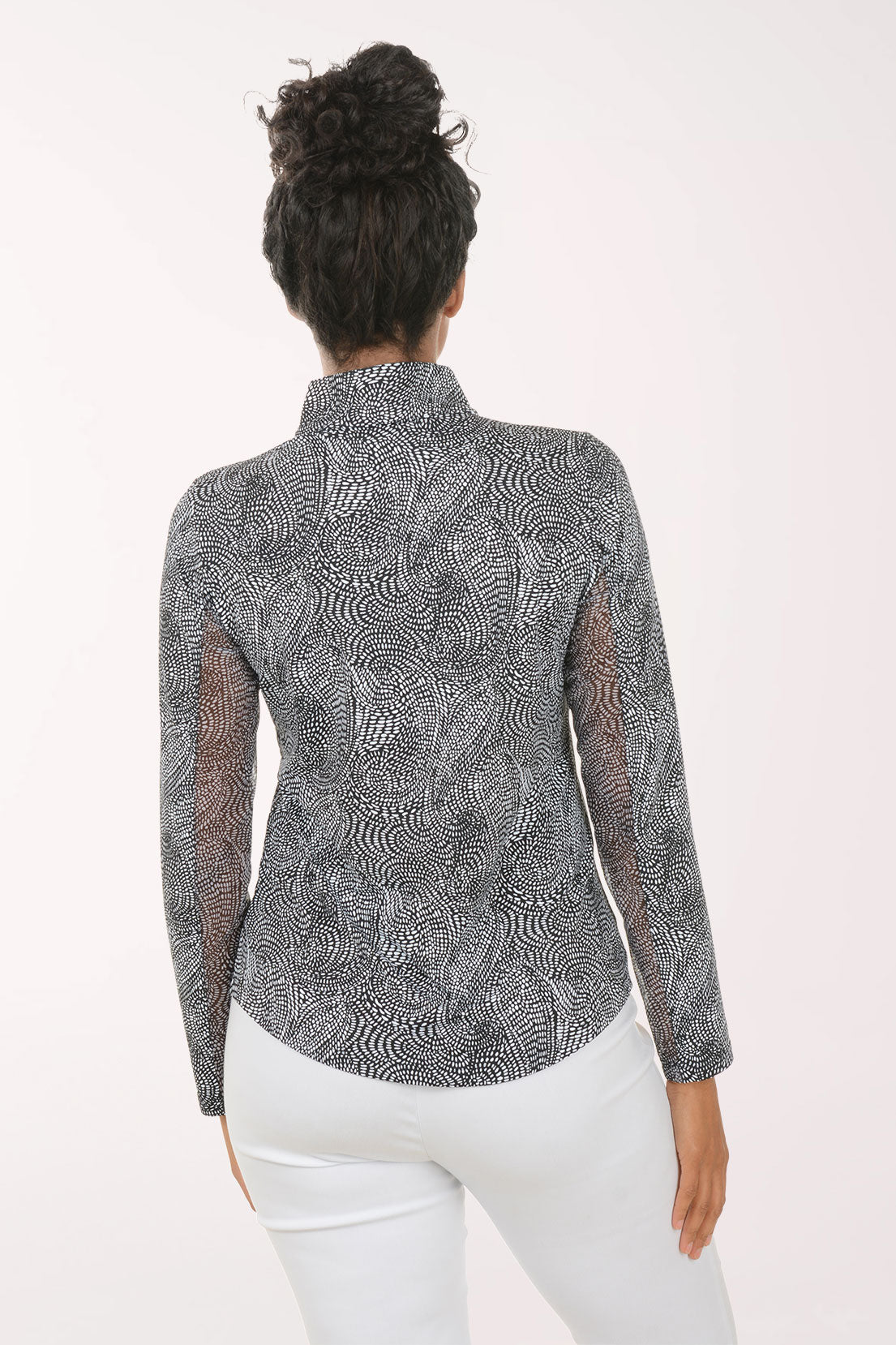 Woman wearing a patterned long-sleeve shirt on a white background