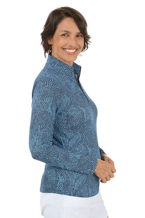 Woman wearing a blue patterned long-sleeve shirt on a white background