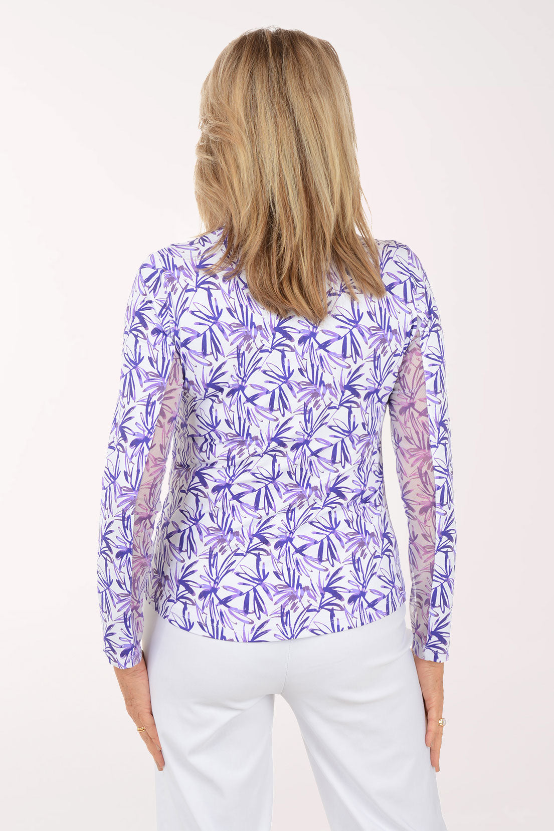 Woman wearing a purple floral patterned shirt on a white background