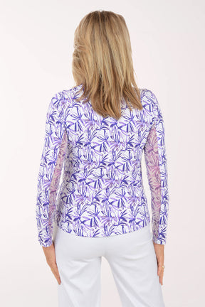 Woman wearing a purple floral patterned shirt on a white background