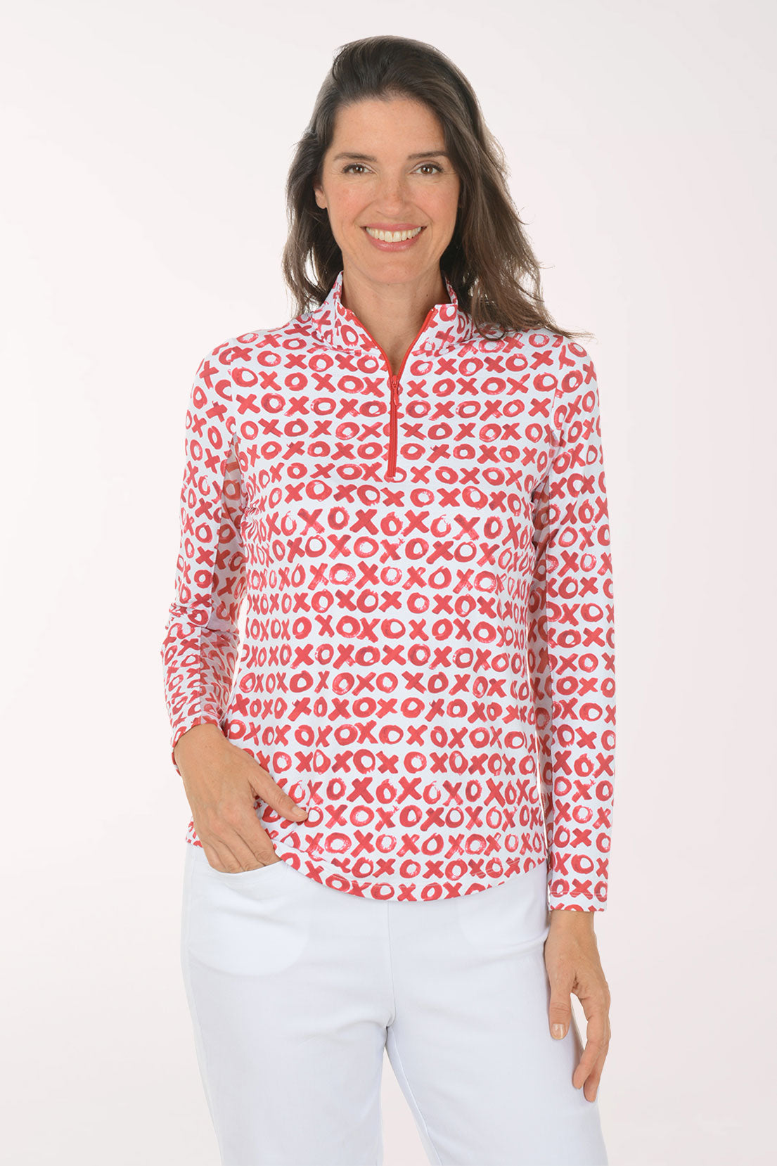 Woman wearing a red and white x and o patterned shirt on a white background