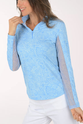 Woman wearing a light blue long-sleeve shirt with mesh accents on a white background