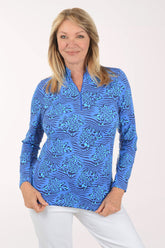 Woman wearing a blue patterned long-sleeve shirt on a white background