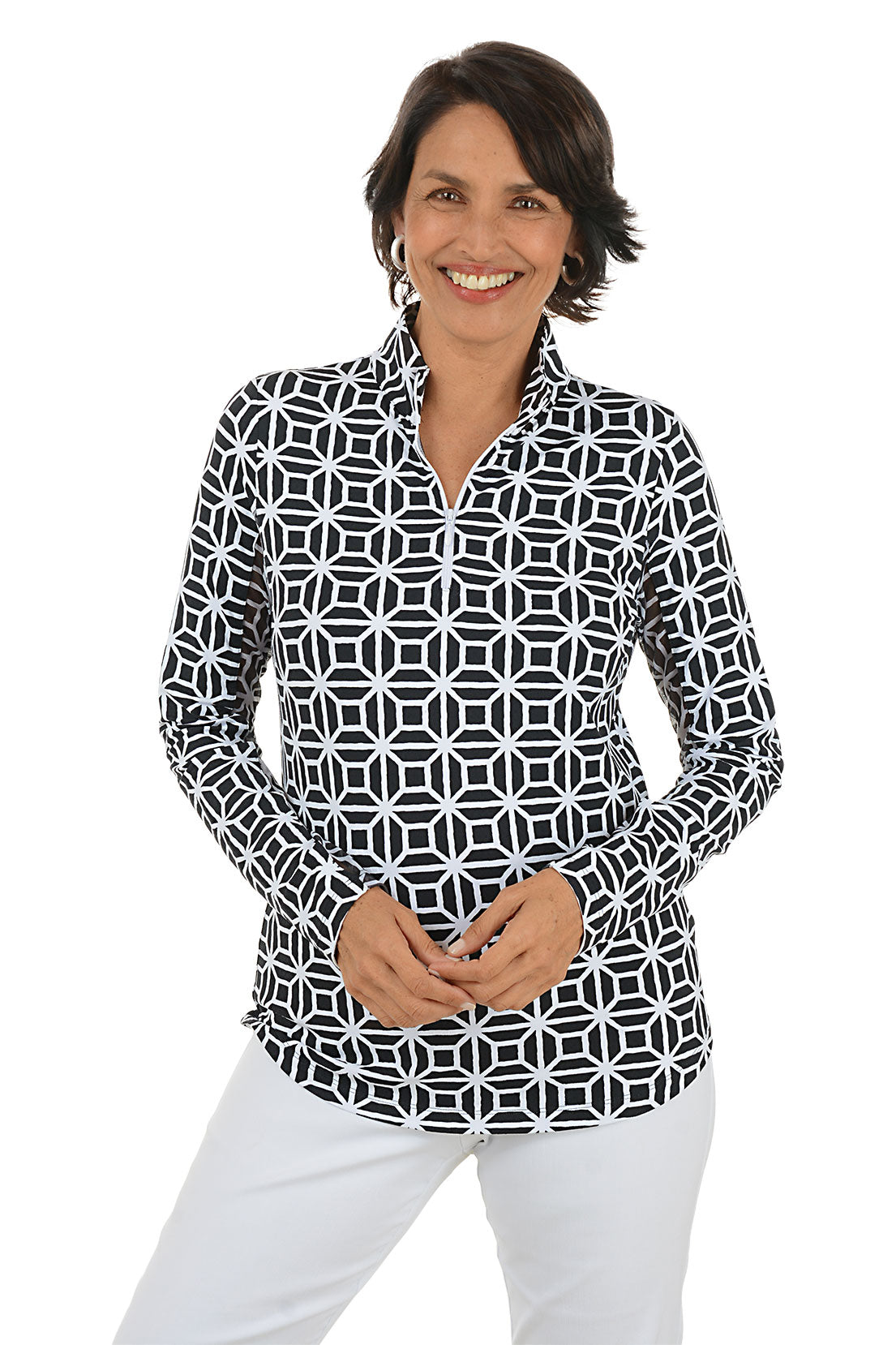 Woman wearing a black geometric patterned shirt with white pants on a white background