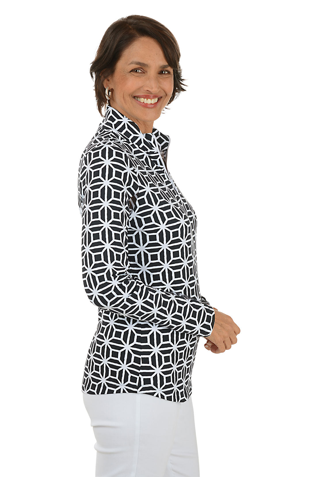 Woman wearing a black geometric patterned shirt with white pants on a white background