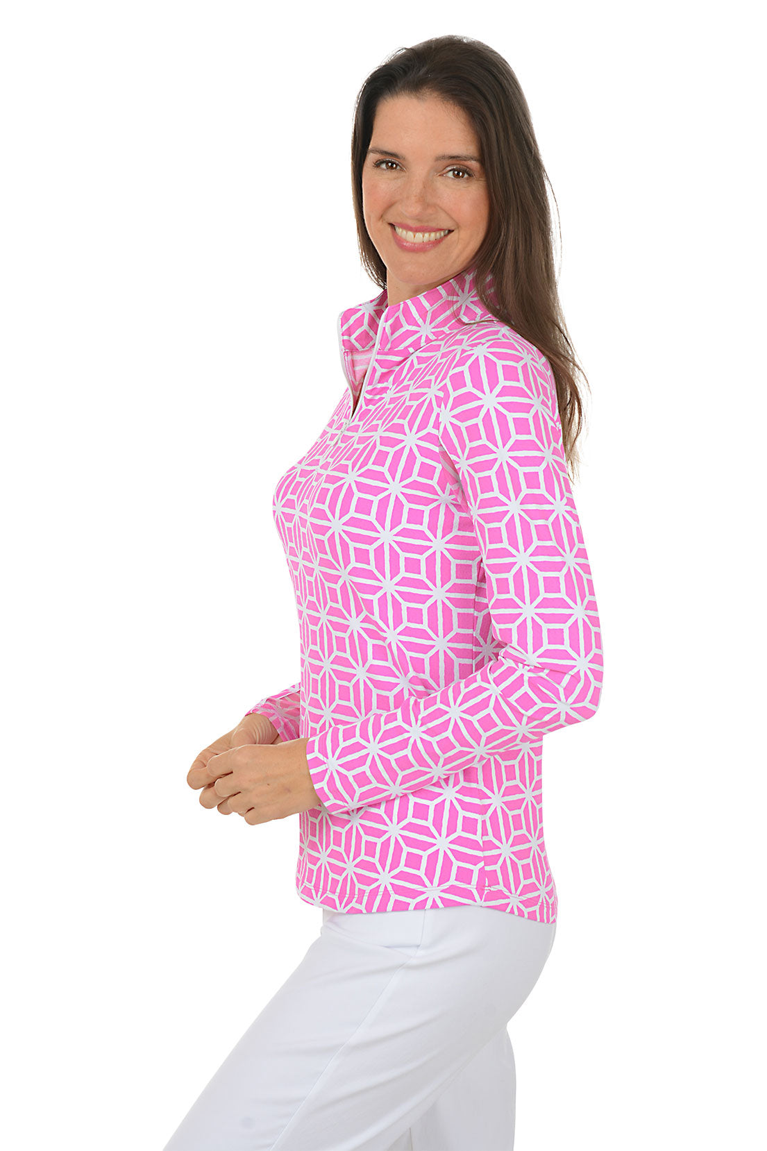Woman wearing a pink geometric patterned shirt with white pants on a white background