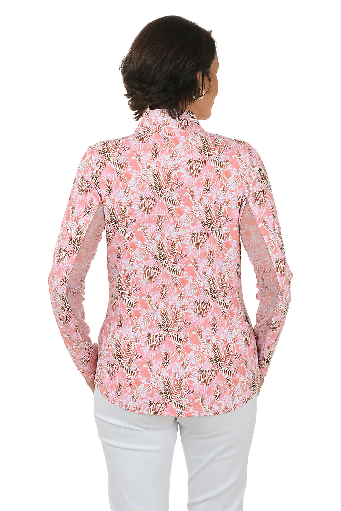 Woman wearing a pink floral blouse with white pants on a white background