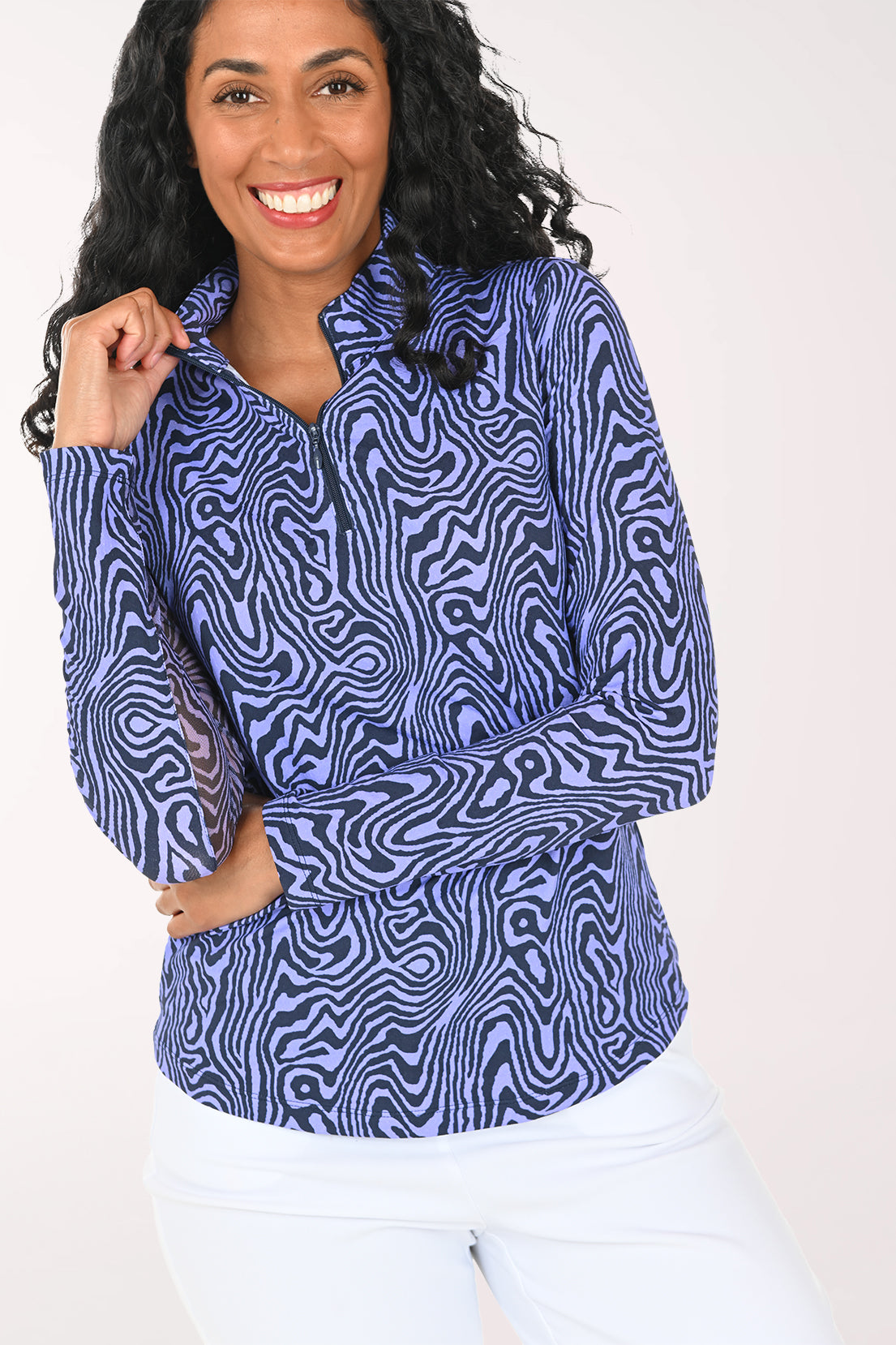 Woman wearing a blue patterned long-sleeve top on a white background