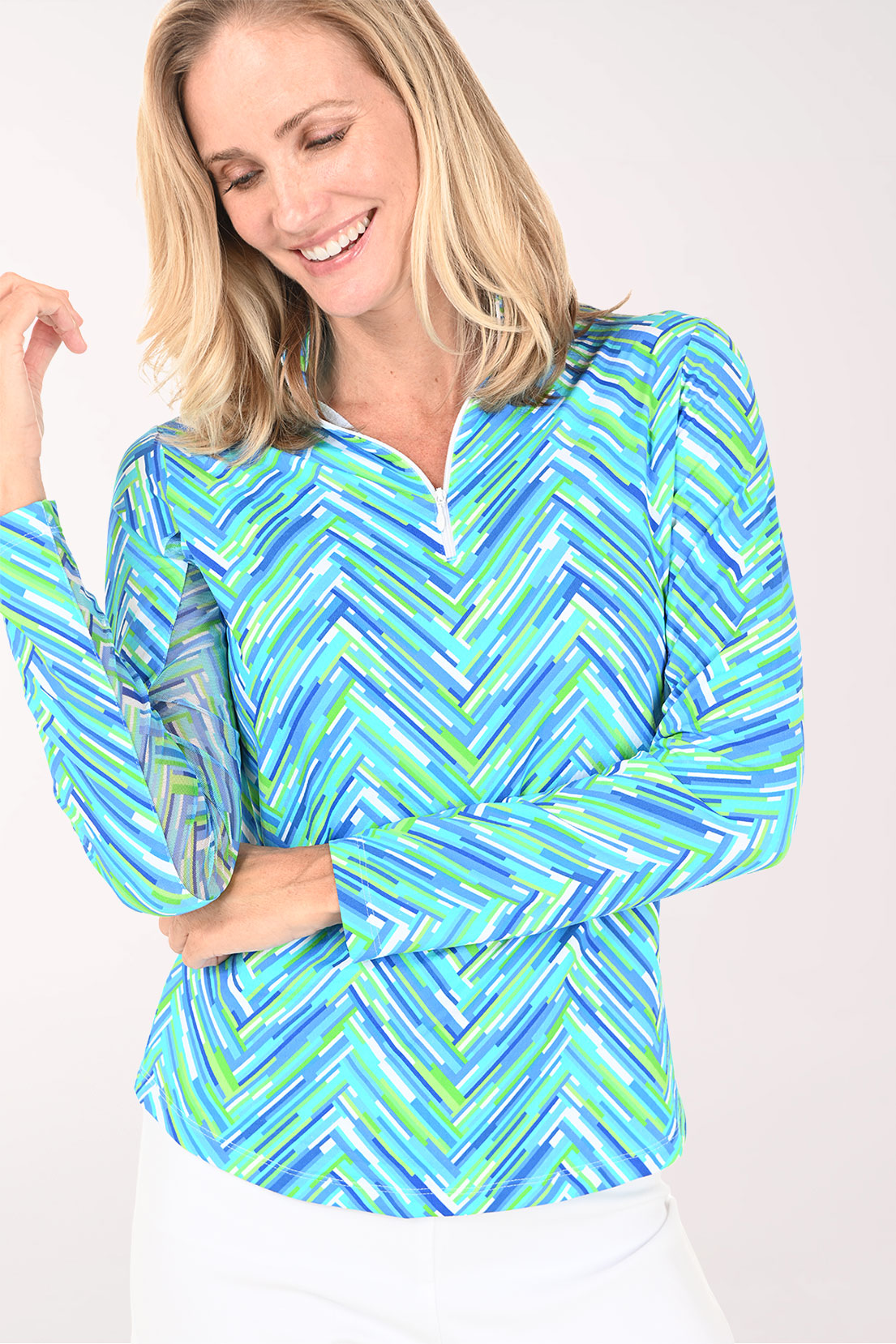 Woman wearing a blue and green patterned long-sleeve shirt on a white background