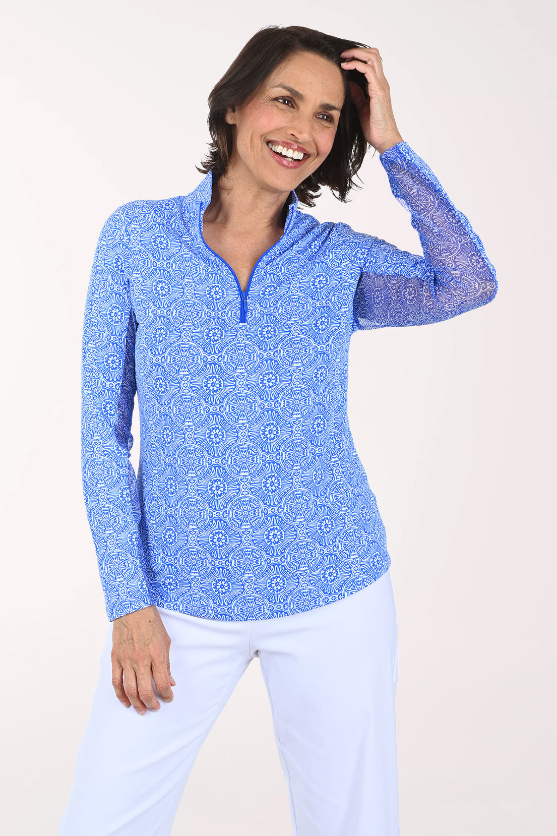 Woman wearing a blue patterned long-sleeve shirt on a white background