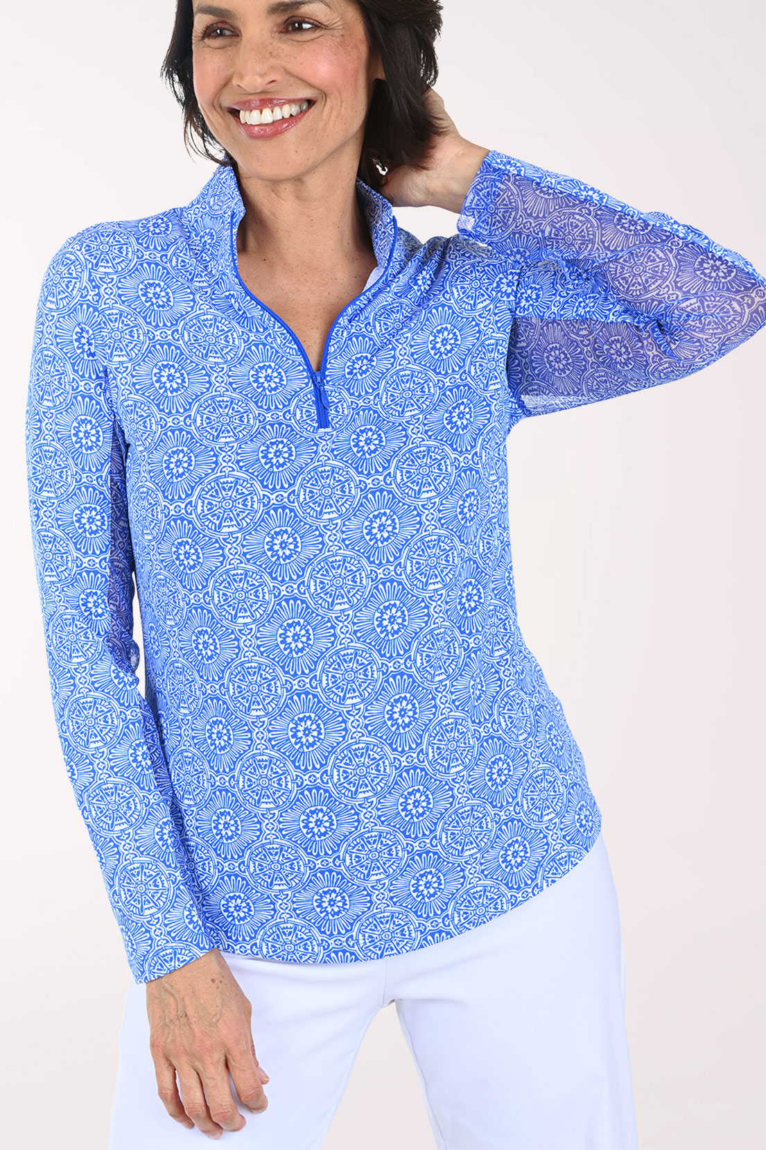 Woman wearing a blue patterned long-sleeve shirt on a white background