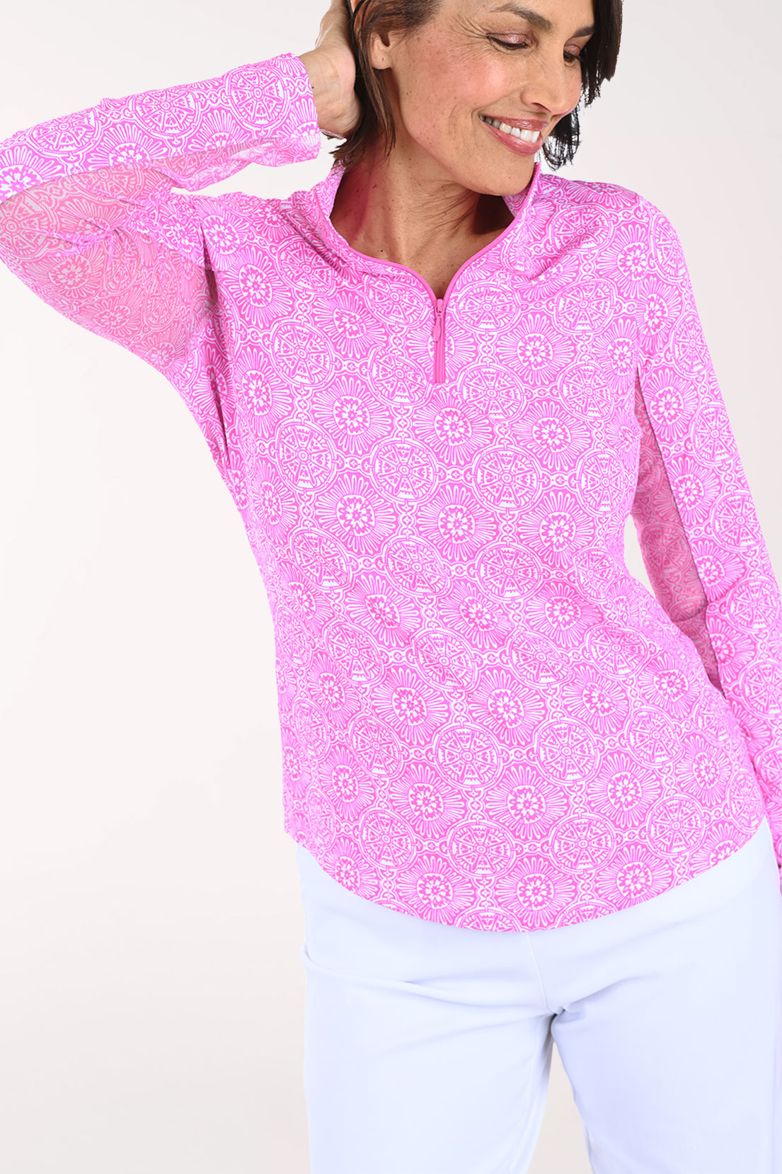 Woman wearing a pink patterned long-sleeve shirt on a white background